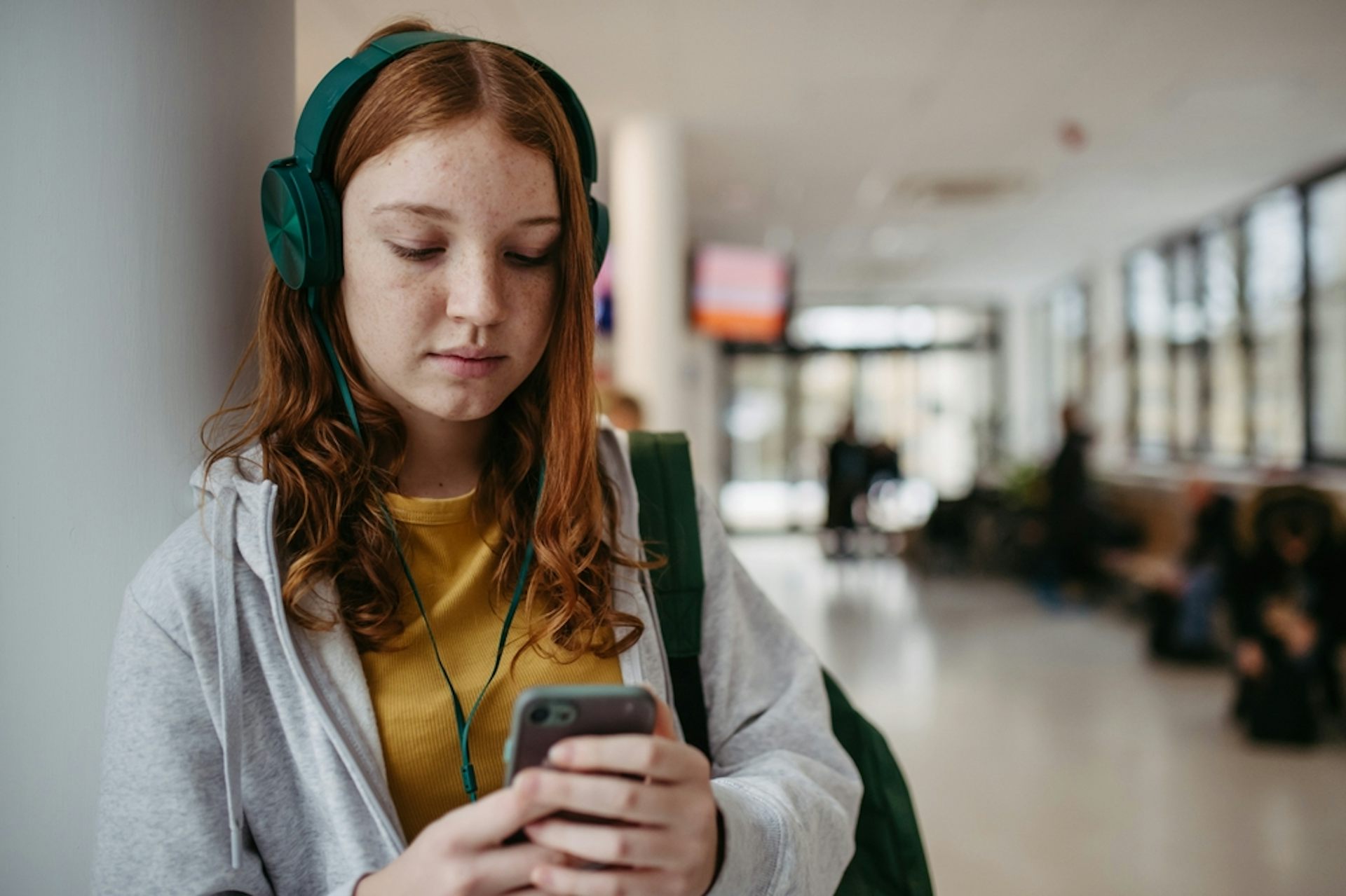 adolescente écoutant de la musique dans un couloir d’administration