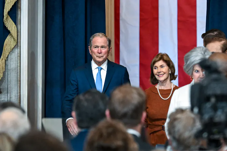 George W. Bush stands beside Laura Bush at Donald Trump's inauguration ceremony.