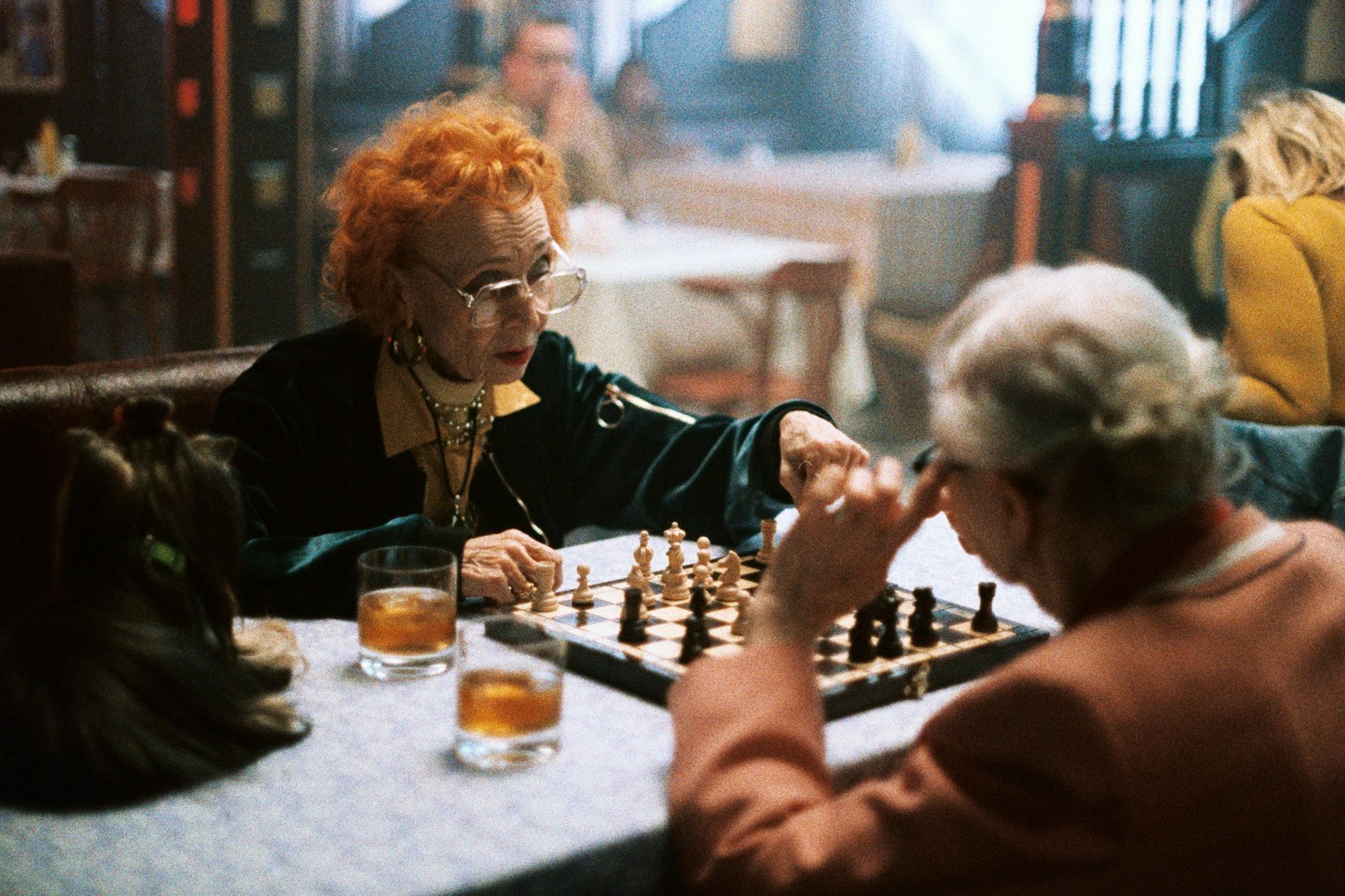 Two older women play chess.