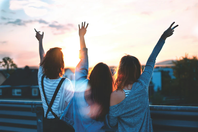 des jeunes heureux lèves les bras