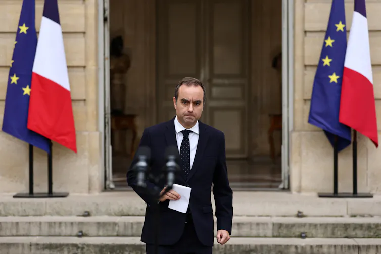 Sébastien Lecornu approaching a microphone.