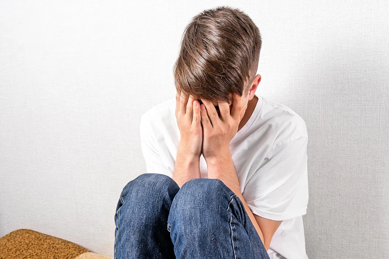 Boy with head in hands