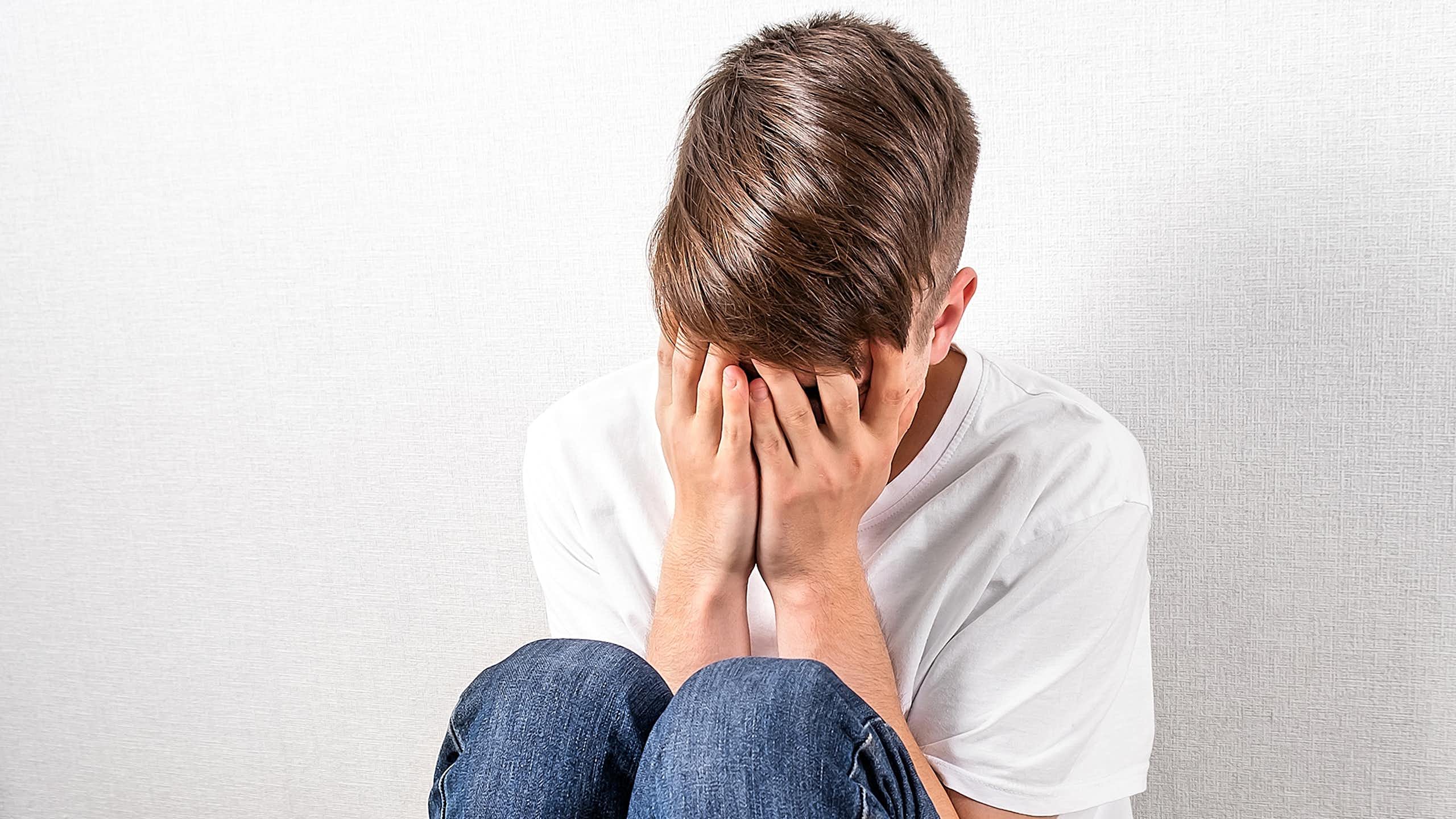 Boy with head in hands