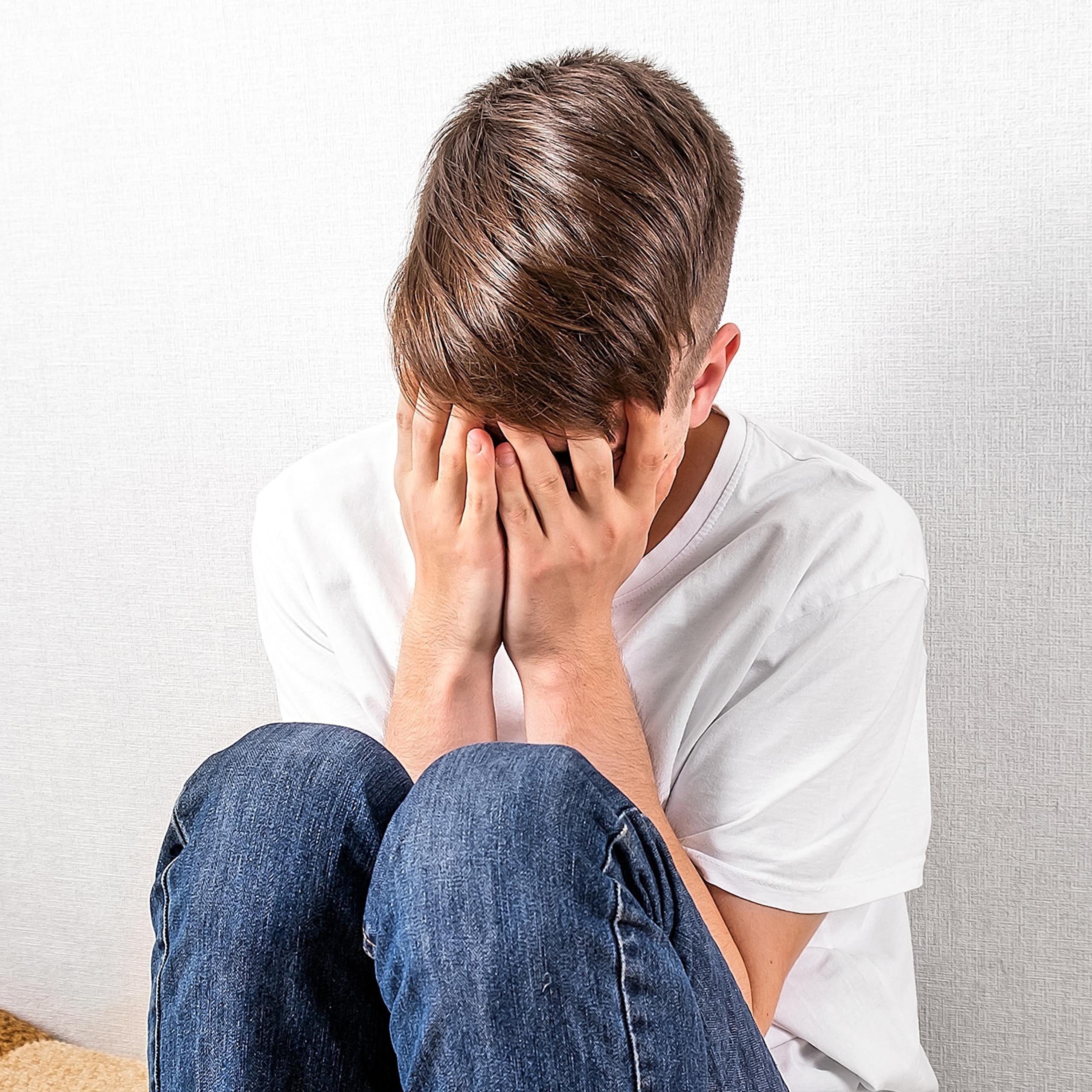 Boy with head in hands