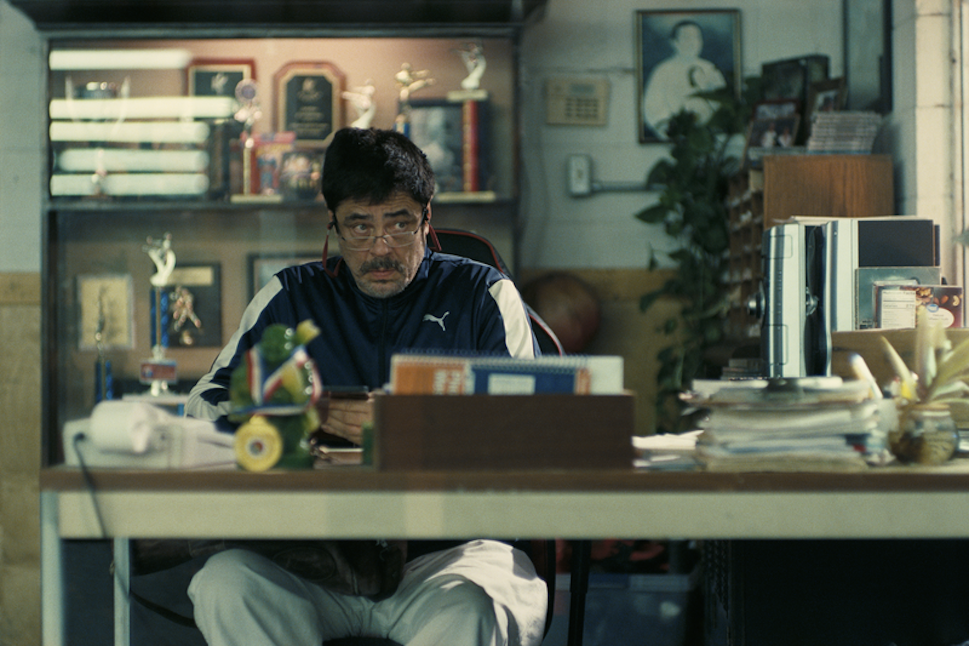 Benicio del Toro sat at a desk, eyebrows raised