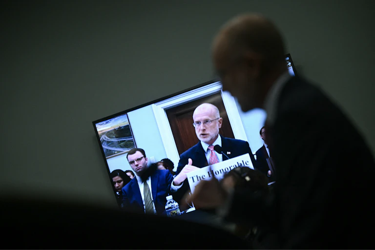 A man on a television monitor speaks.