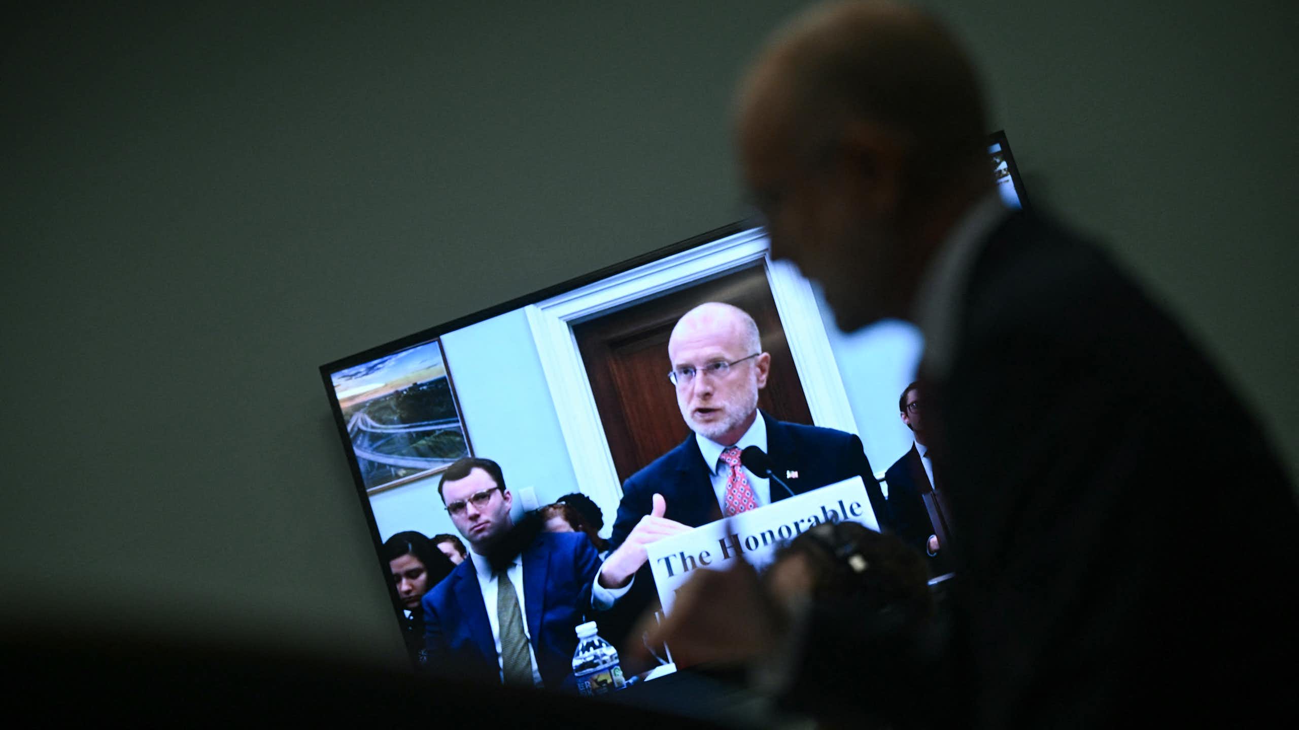 A man on a television monitor speaks.