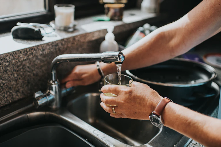 Person fills a glass with tap water