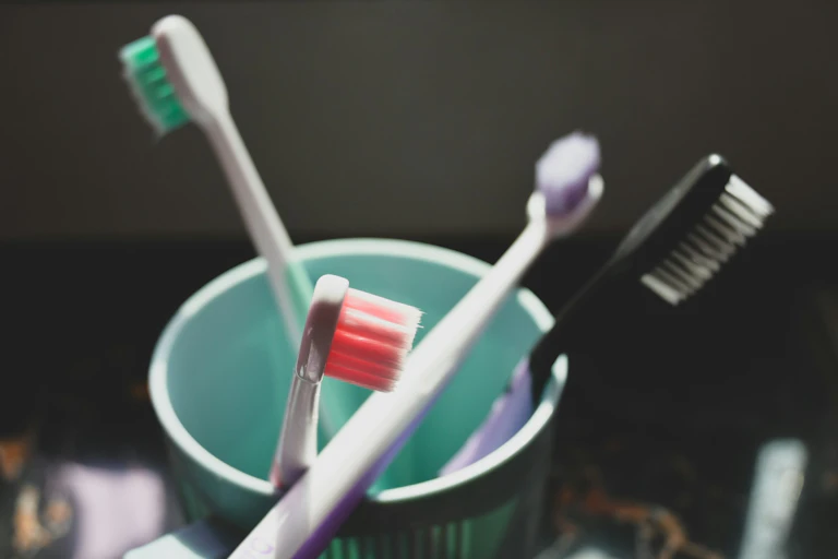 Toothbrushes in cup against black background