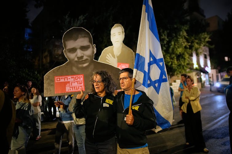 People marching with pictures of Israeli hostages held by Hamas.
