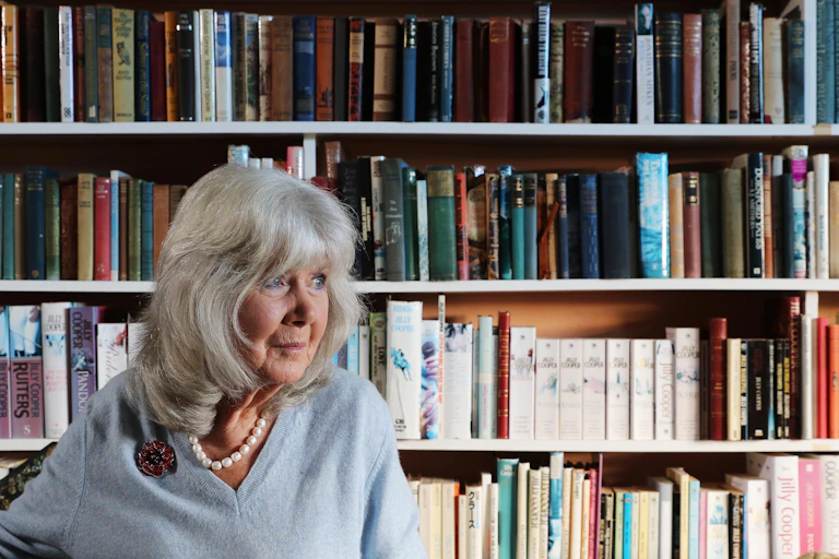 Jilly Cooper in front of a bookshelf