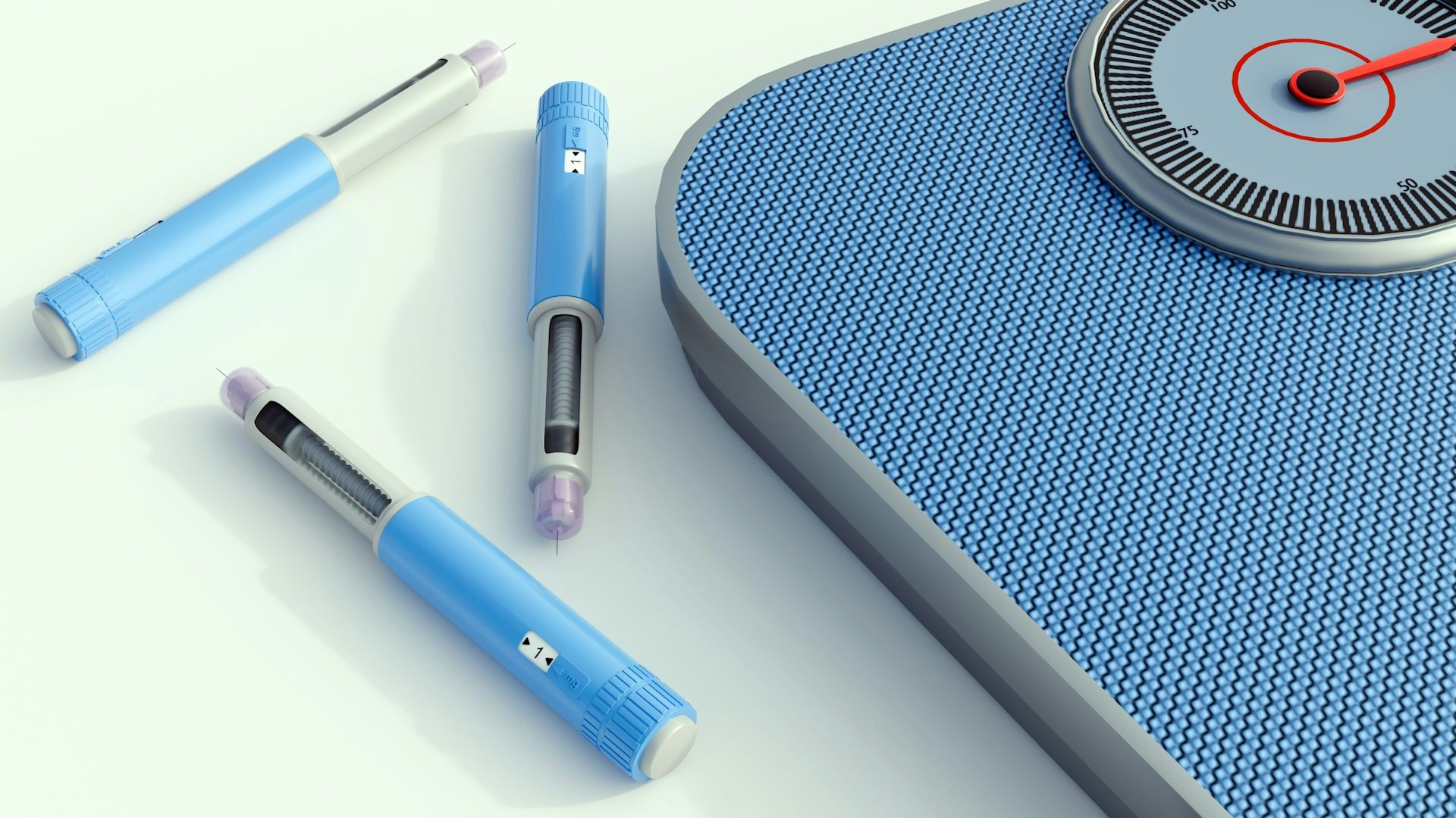 A blue scale, with three vials of blue weight loss jabs next to it.