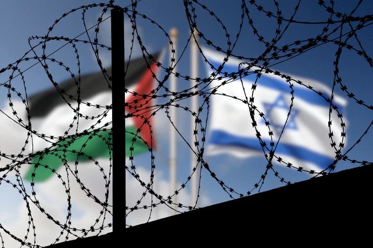 A composite picture of an Israeli flag and a Palestinian flag with barbed wire in the foreground.