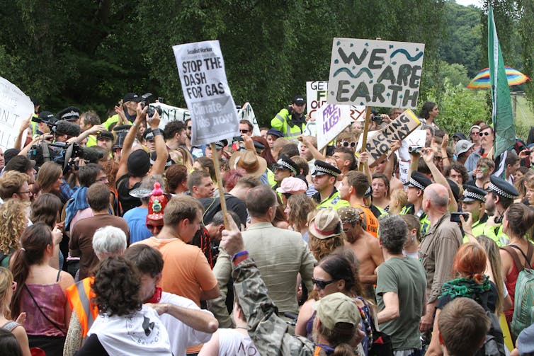 A group of protesters with signs reading 'we are earth'