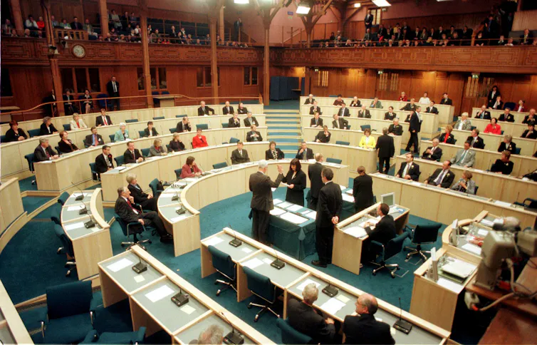 Members of the Scottish parliament taking an oath in the chamber.