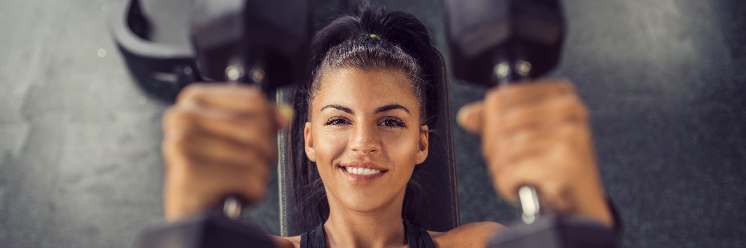 Woman holding two dumbbells.