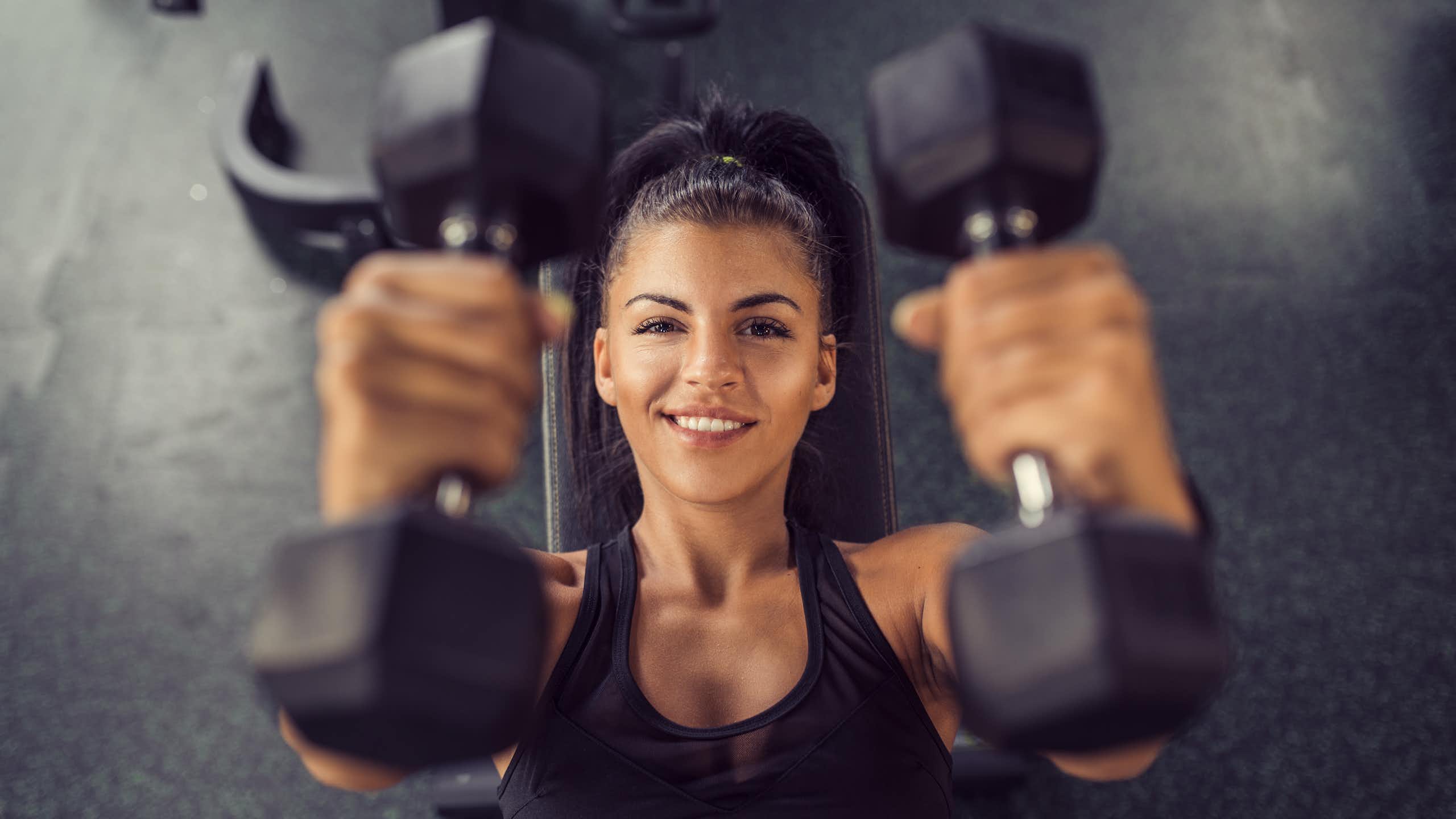 Woman holding two dumbbells.