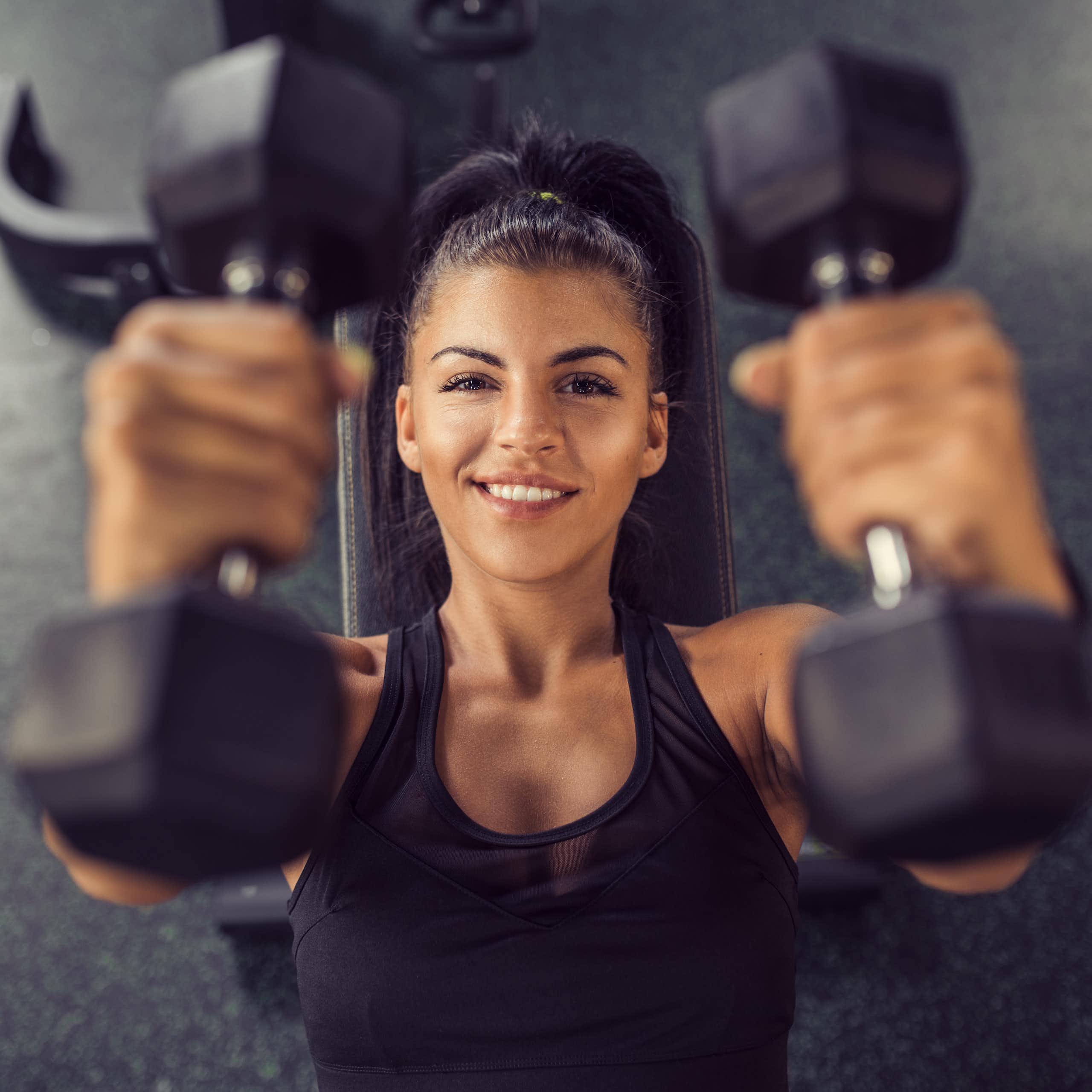 Woman holding two dumbbells.