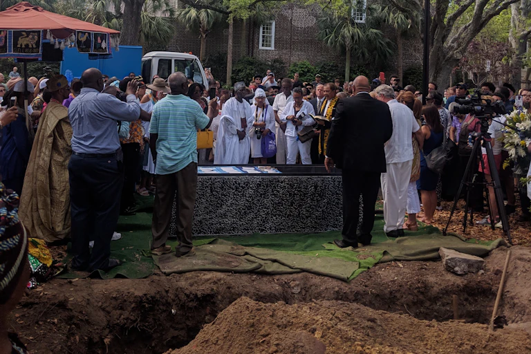 People gather around a burial vault.