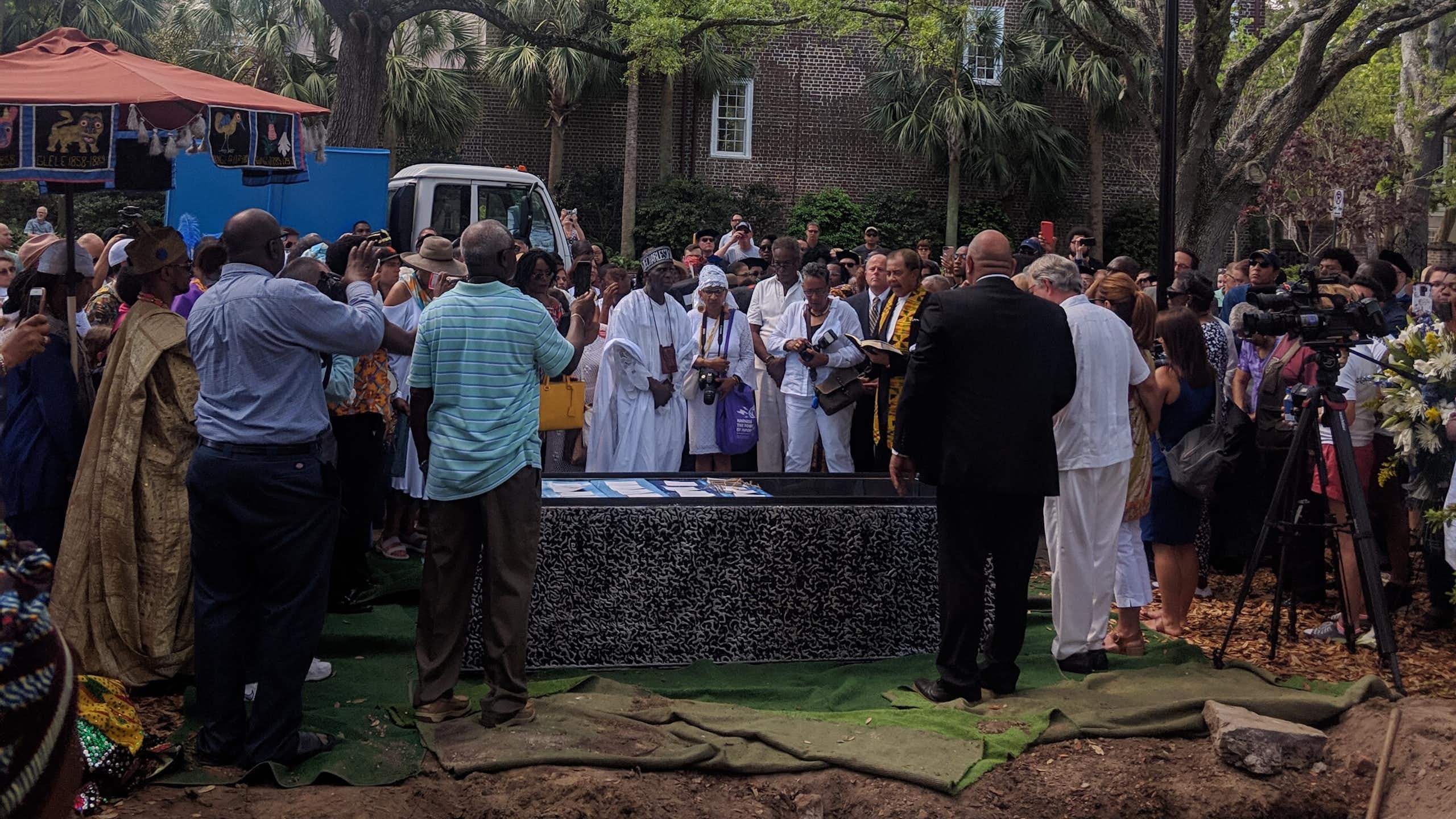 People gather around a burial vault.