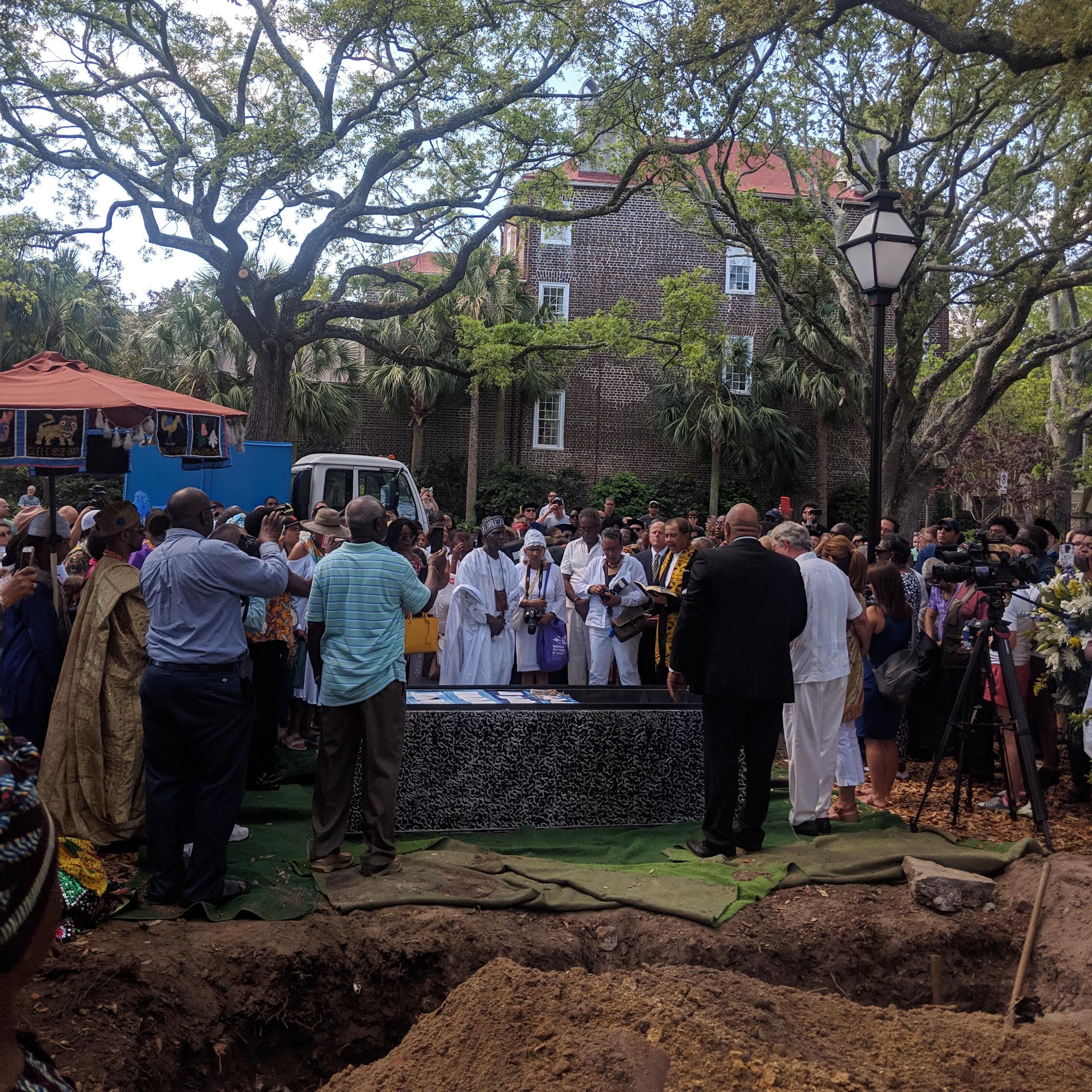 People gather around a burial vault.