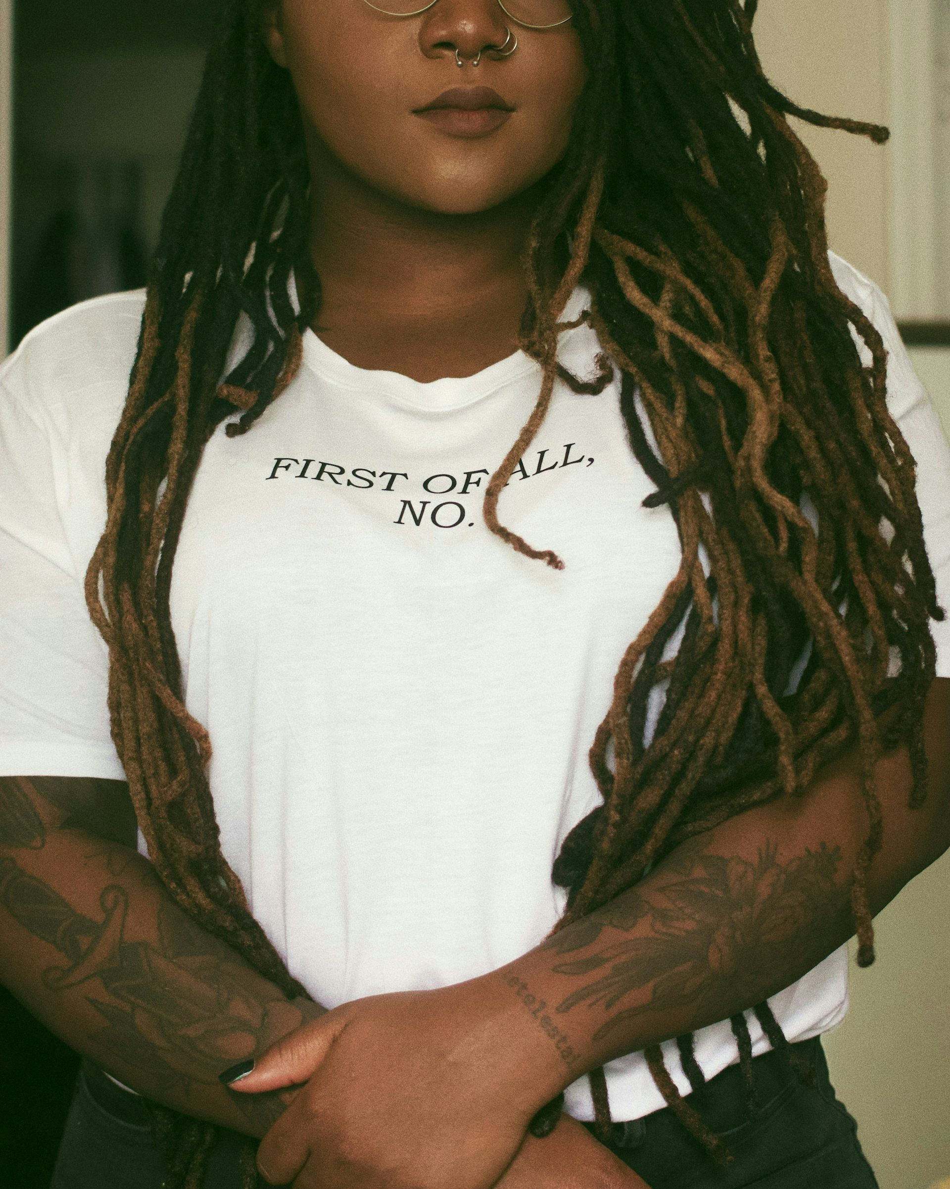 A Black woman in a t-shirt that says, 'first of all, no'