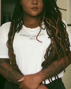 A Black woman in a t-shirt that says, 'first of all, no'