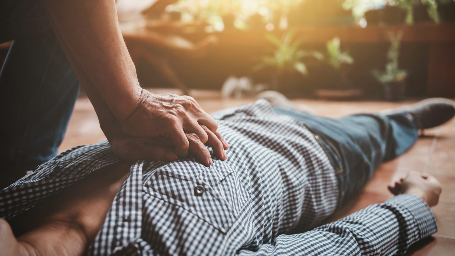 Un hombre posa las manos sobre el pecho de otro hombre tumbado.