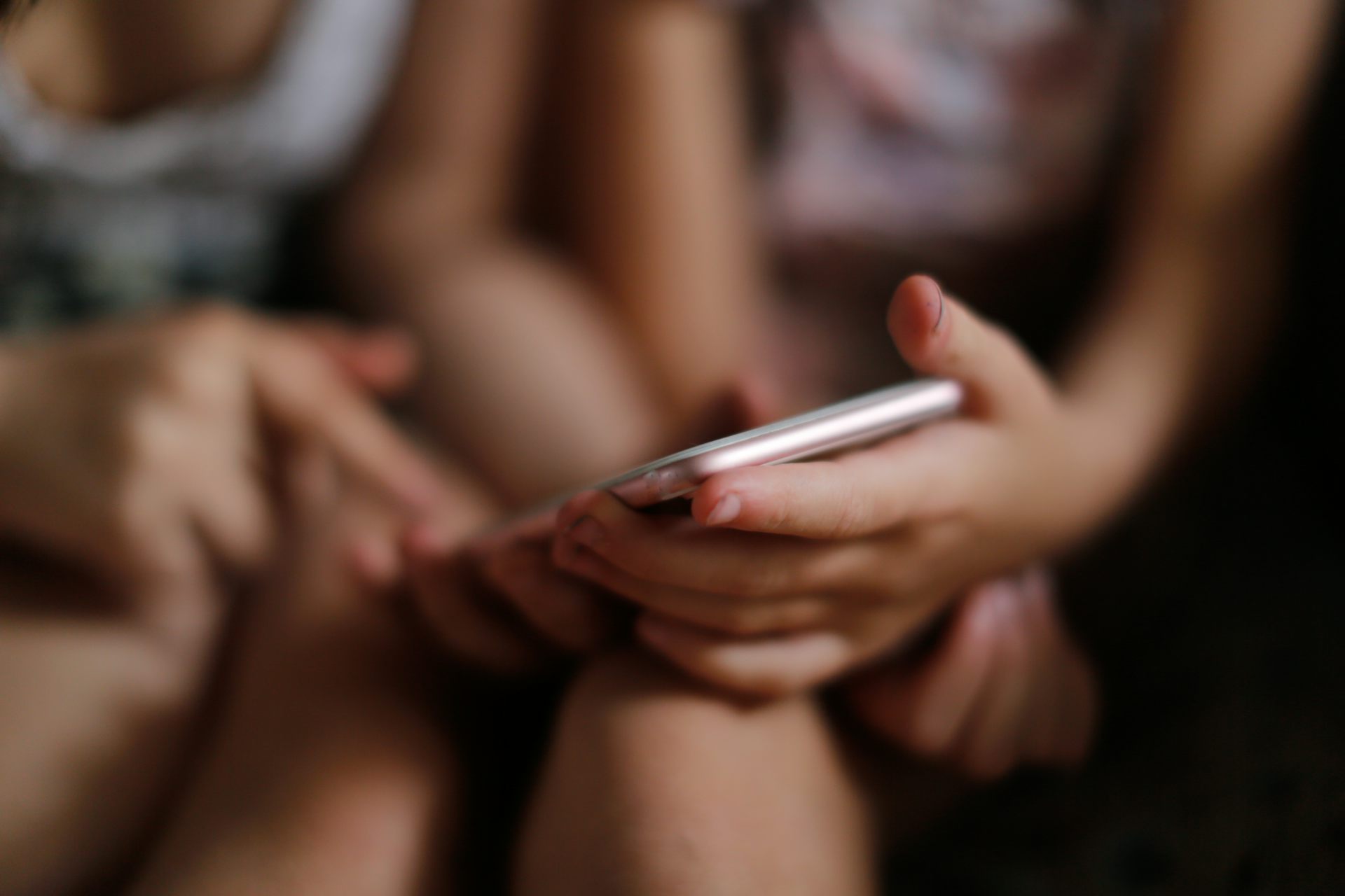 Children girls with a smartphone, children scare and threaten the phone.