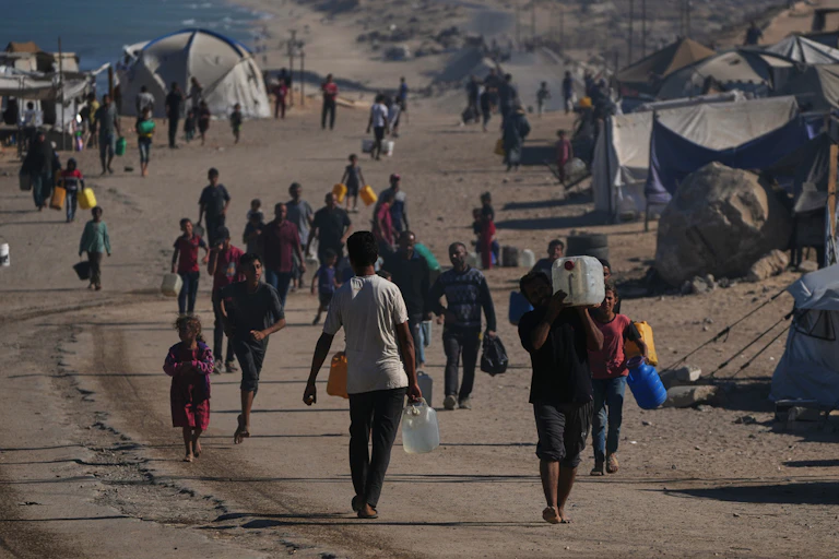 Displaced persons walk on a road.