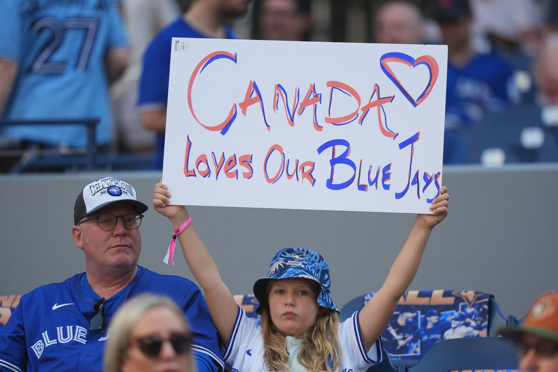 La joven sostiene un cartel que dice: Canadá ama a nuestro Jaike azul en el juego de Jais-Yankees.