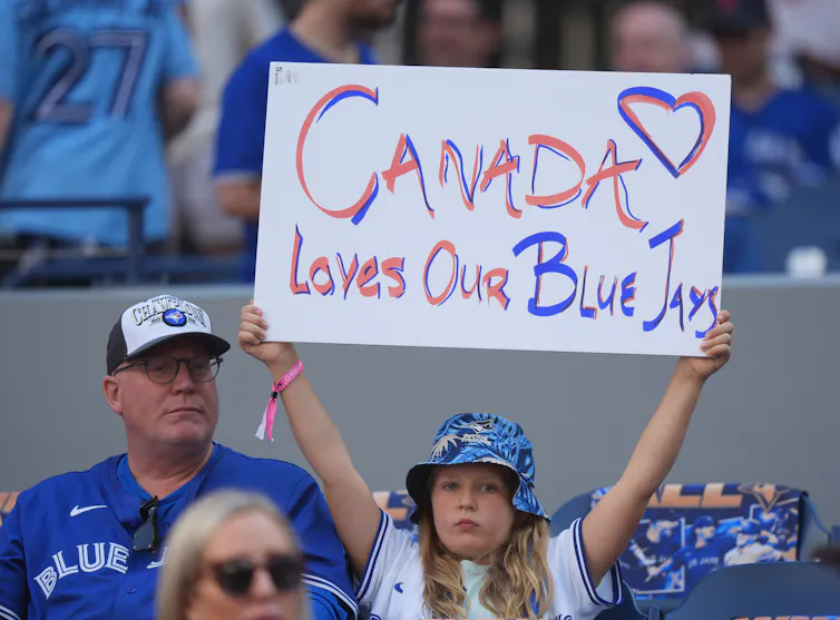 La joven sostiene un cartel que dice: Canadá ama a nuestro Jaike azul en el juego de Jais-Yankees.