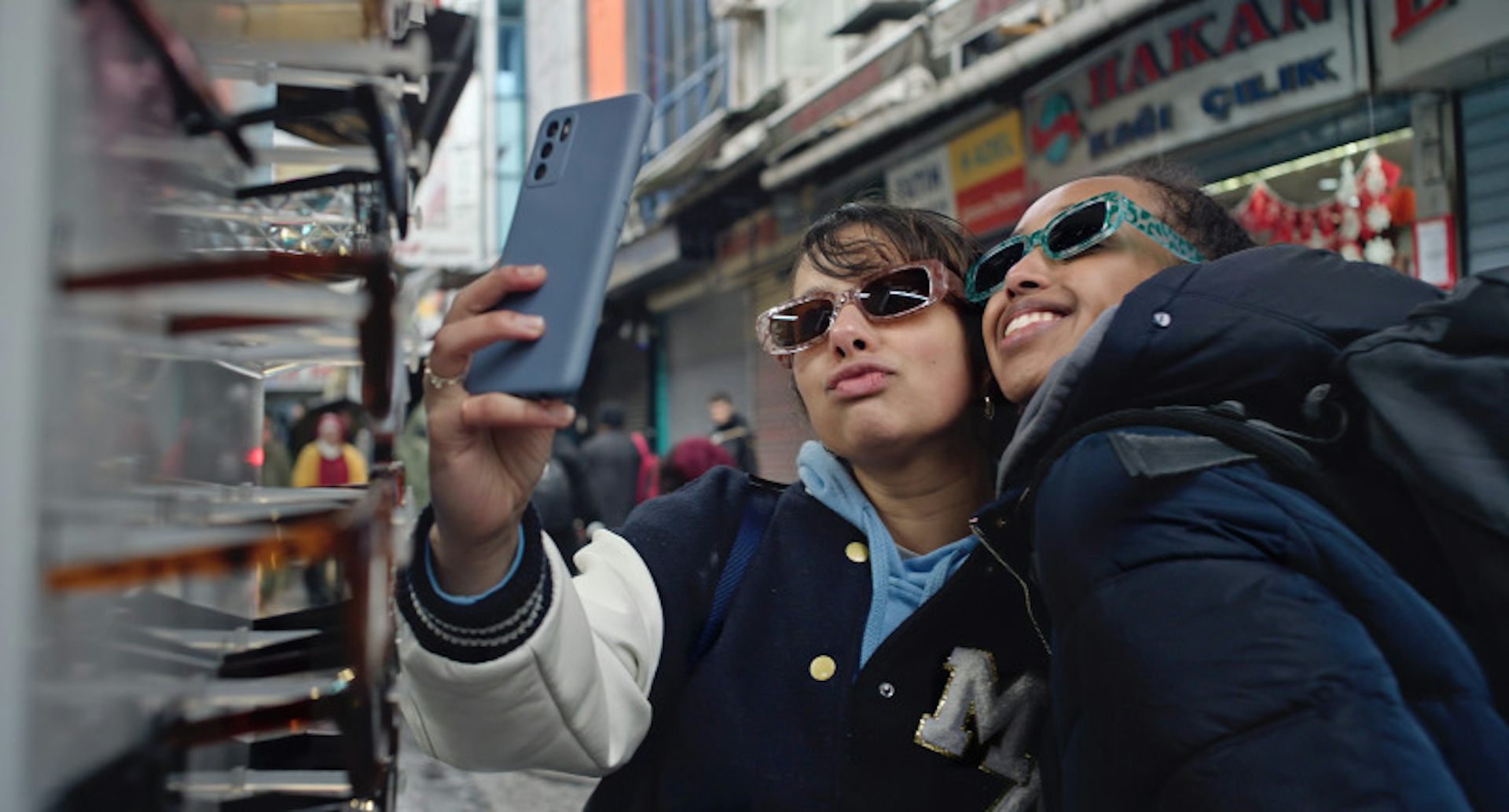 Two girls taking a selfie while trying on sunglasses