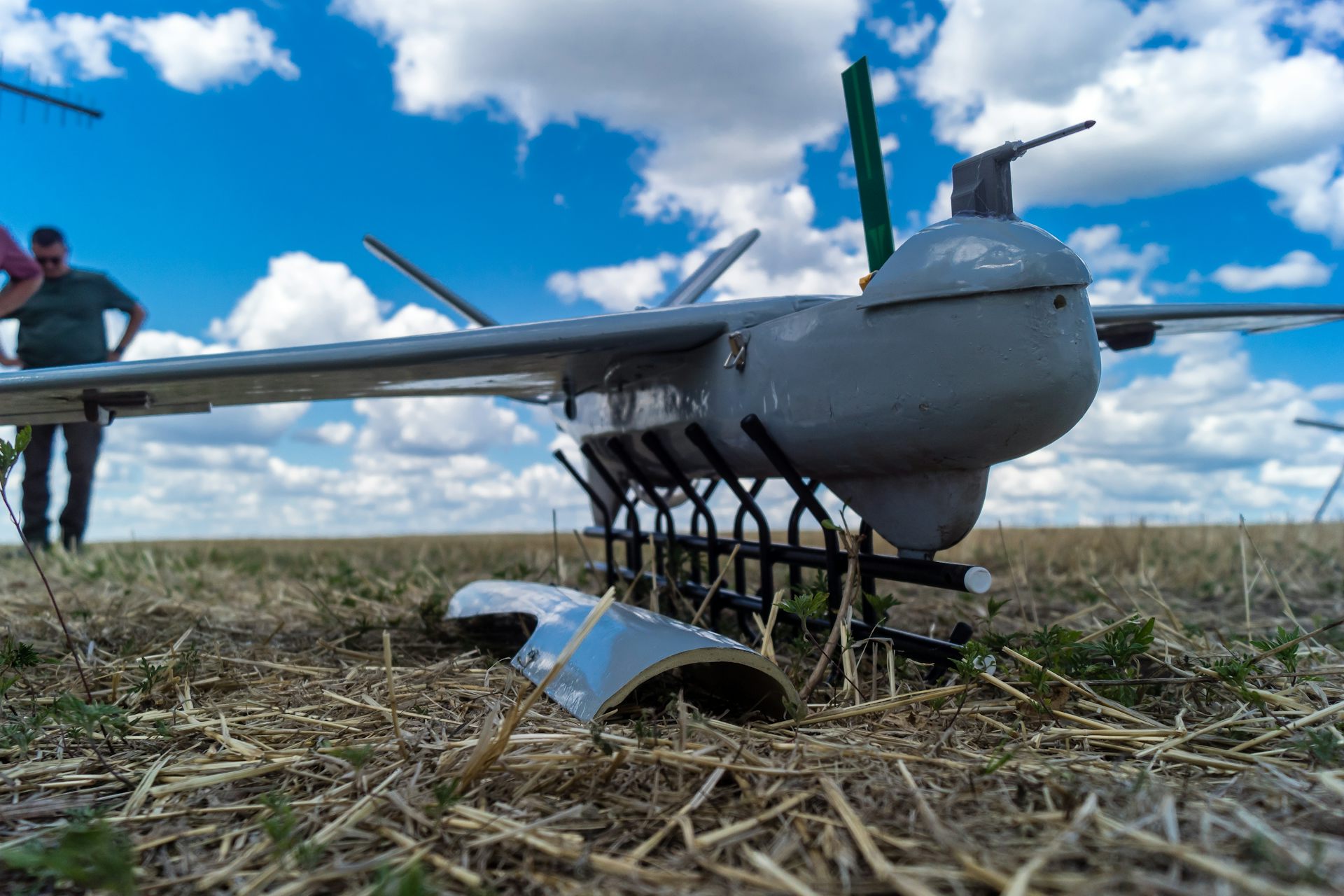 A Ukrainian soldier programmes a drone in a field.