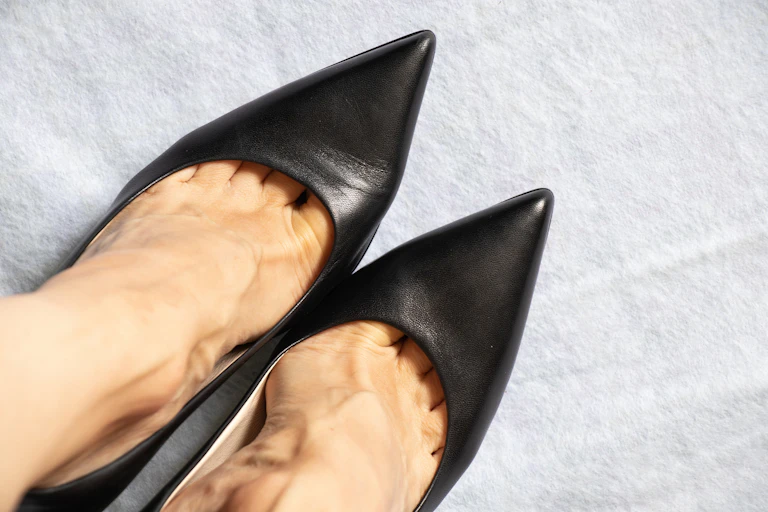 Close-up of feet wearing pointy black shoes