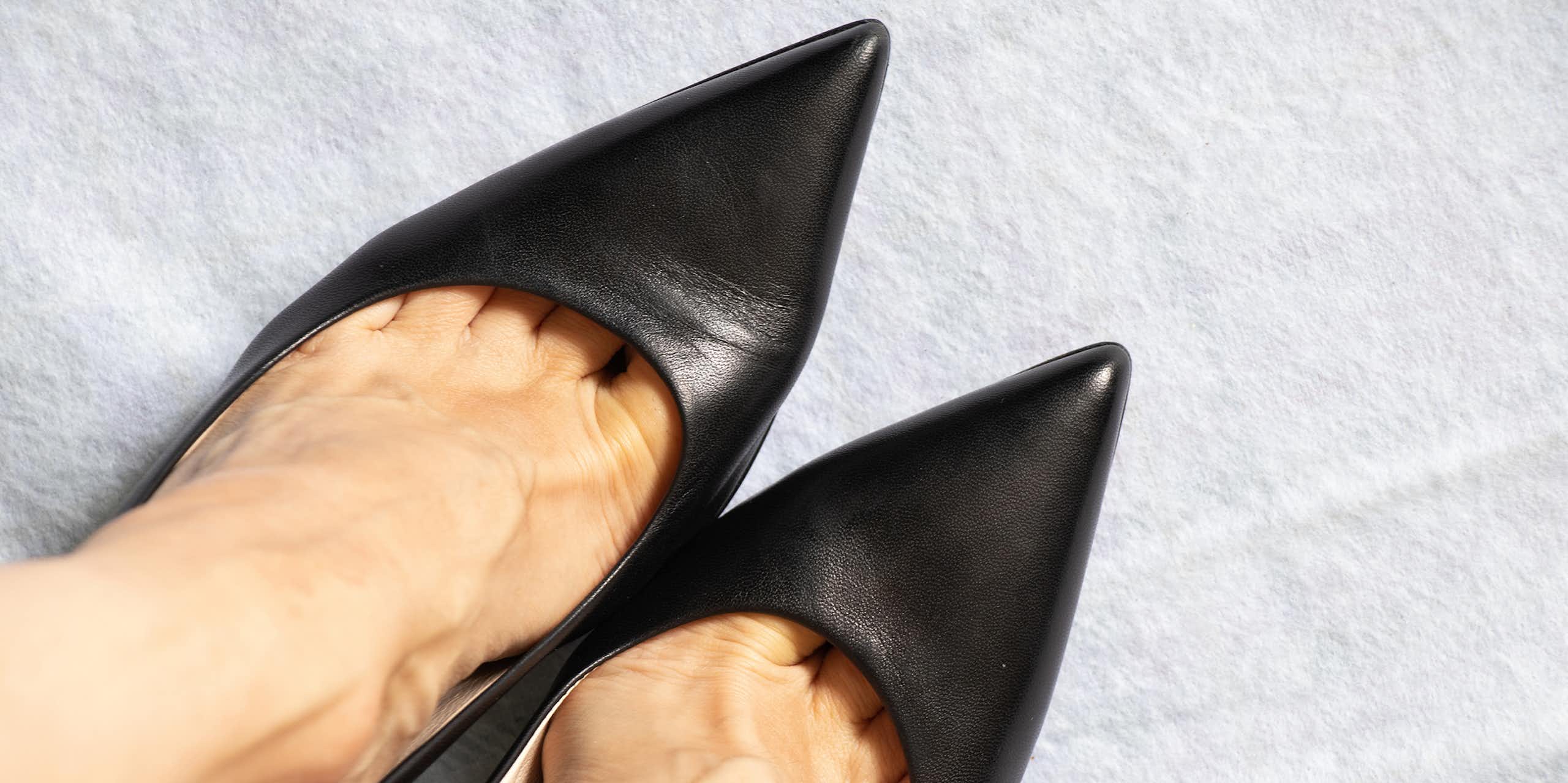 Close-up of feet wearing pointy black shoes