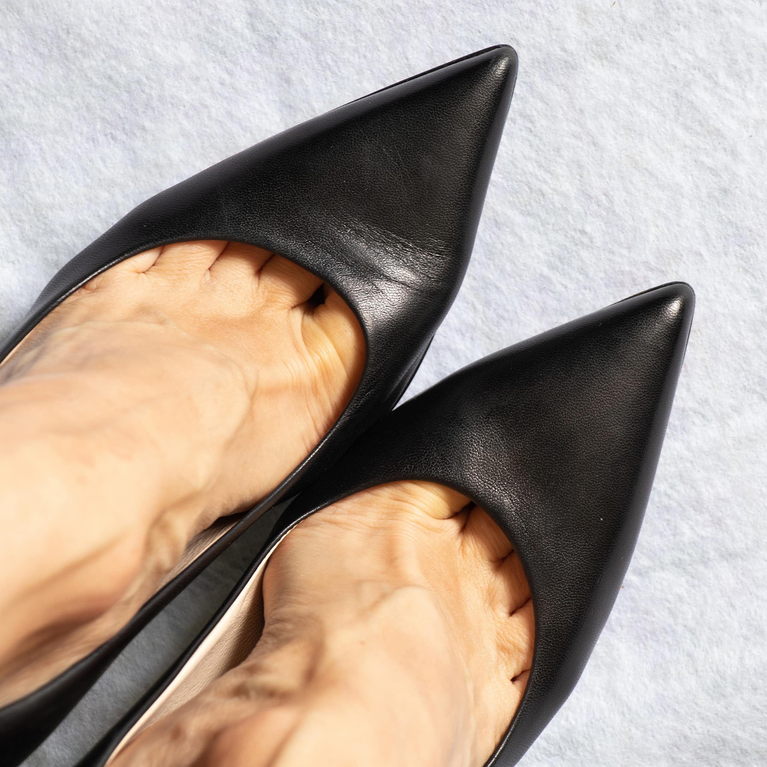 Close-up of feet wearing pointy black shoes