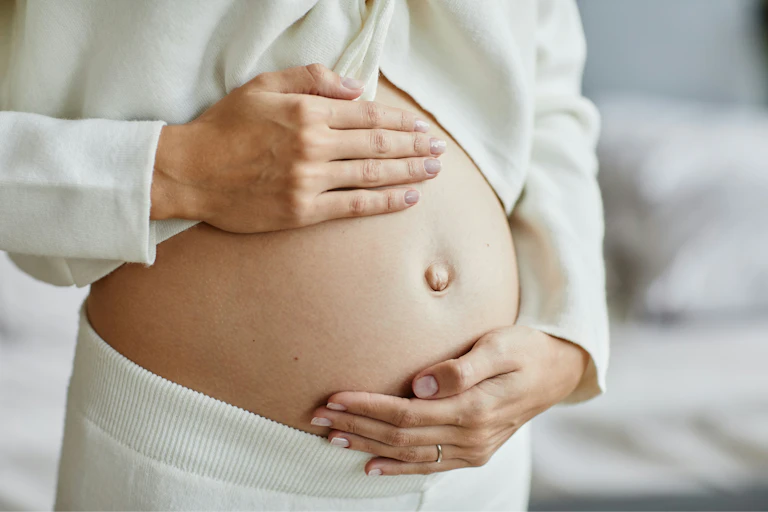Une femme enceinte flatte son ventre