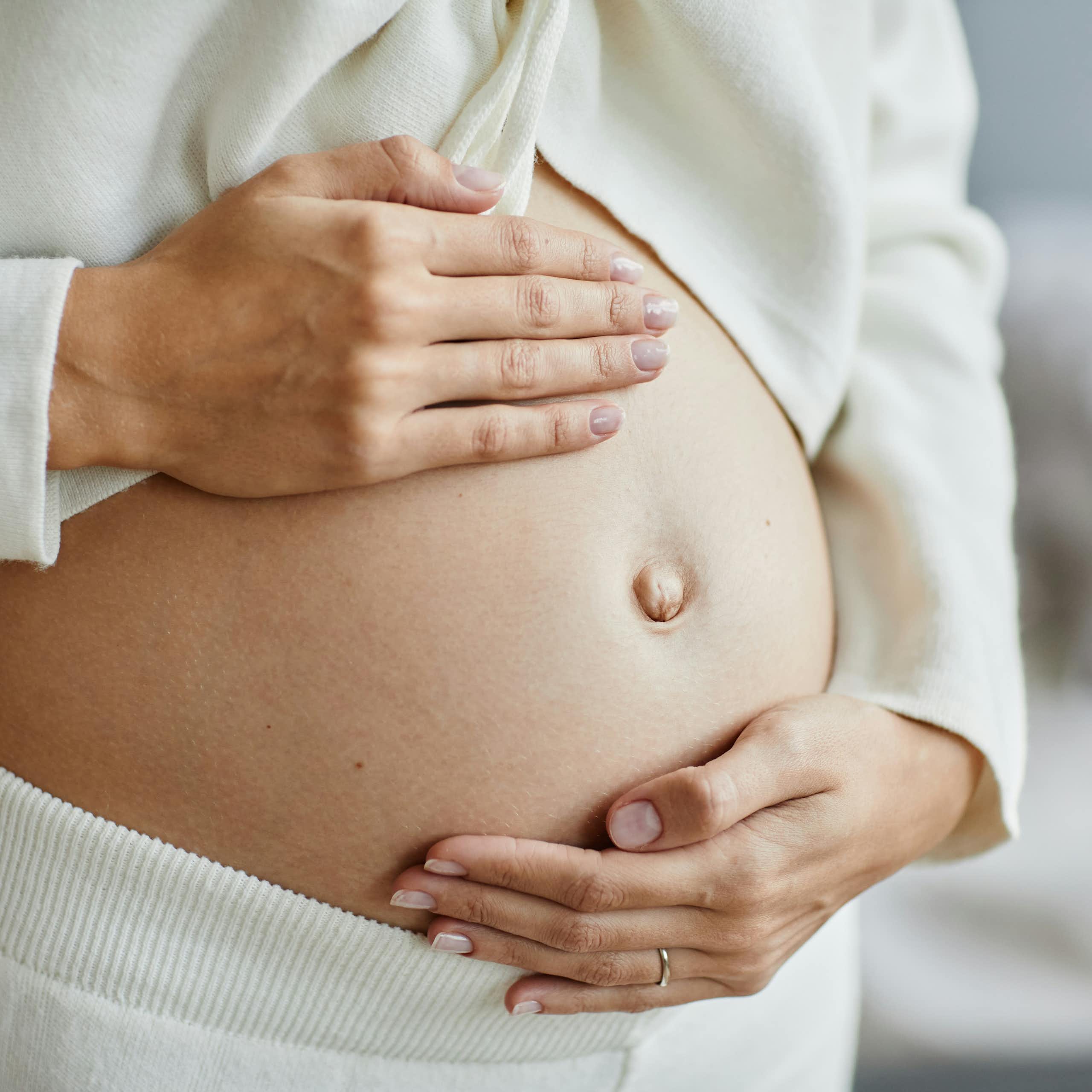 Une femme enceinte flatte son ventre