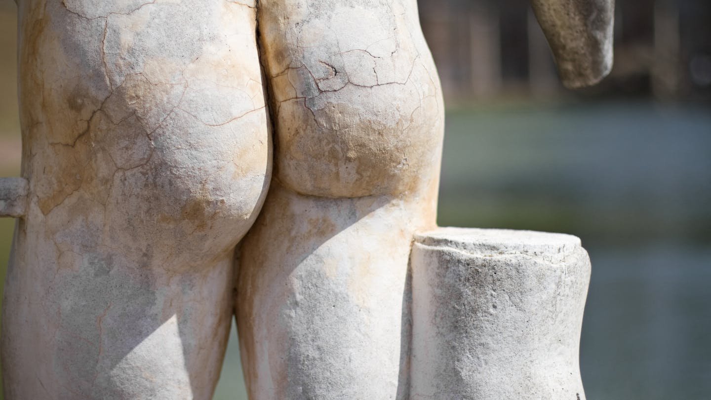 Rear review of ancient Greek statue, showing buttocks