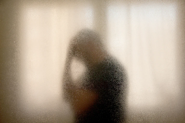 Silhouette of middle aged man holding his head.