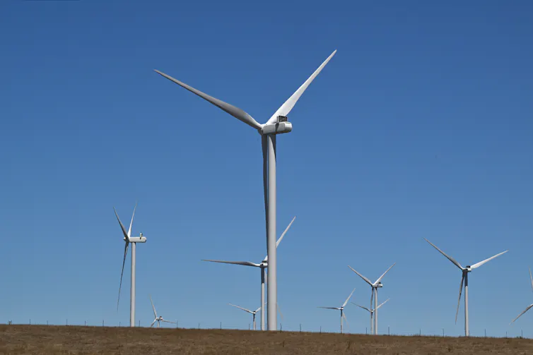 A large white wind turbine in an open field.