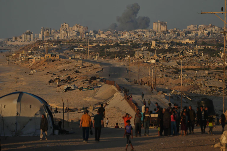 Palestinos cargando sus pertenencias caminan por una carretera al sur de la ciudad de Gaza, el 8 de octubre de 2025.