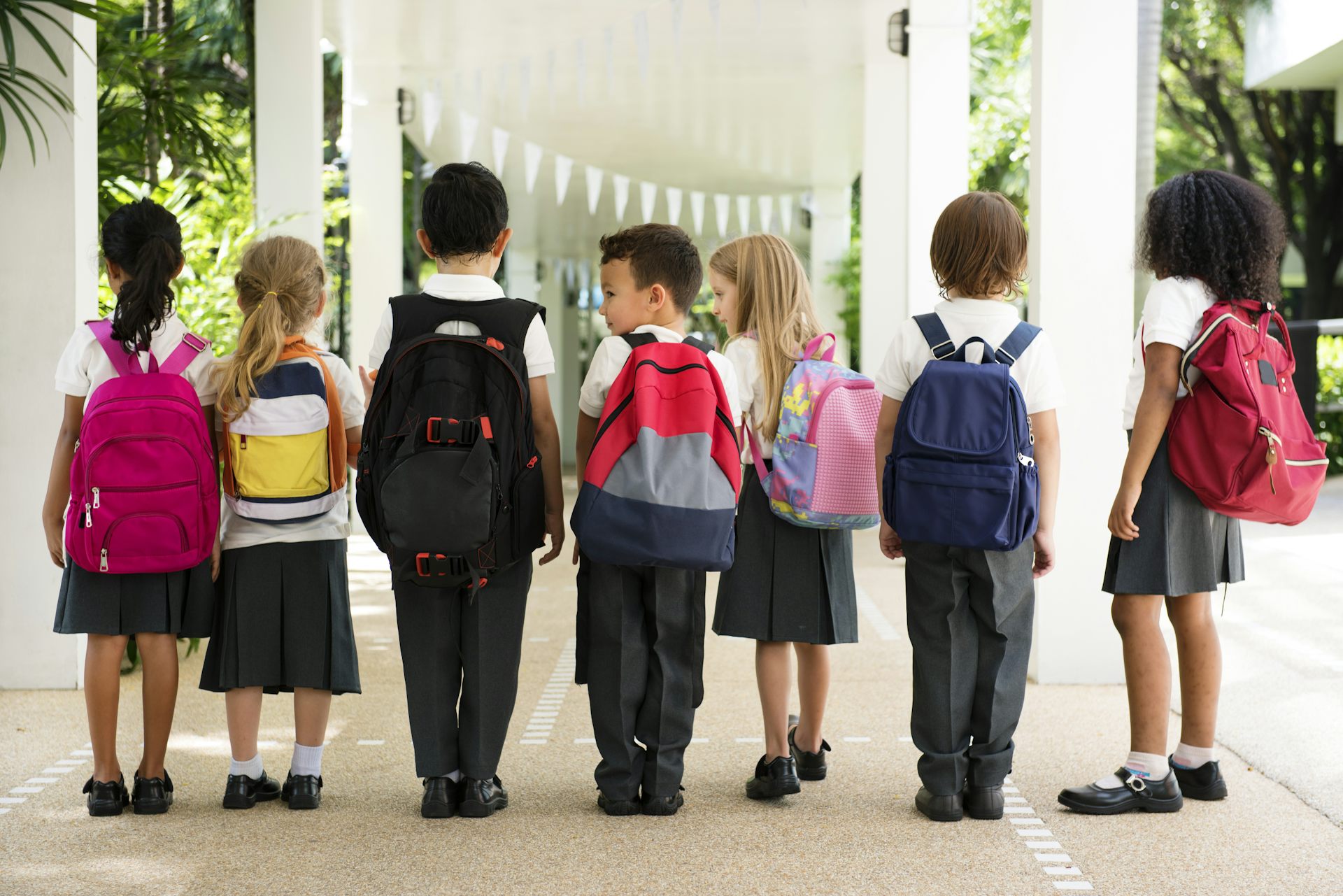 Group of children in uniform with backpacks