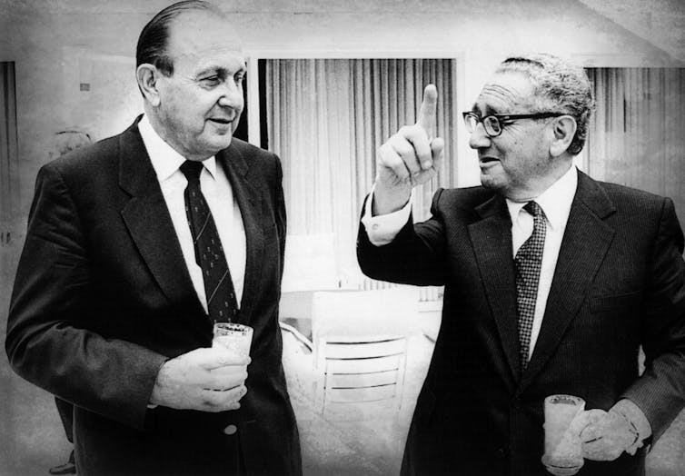 Henry Kissinger e Hans-Dietrich Genscher conversam.