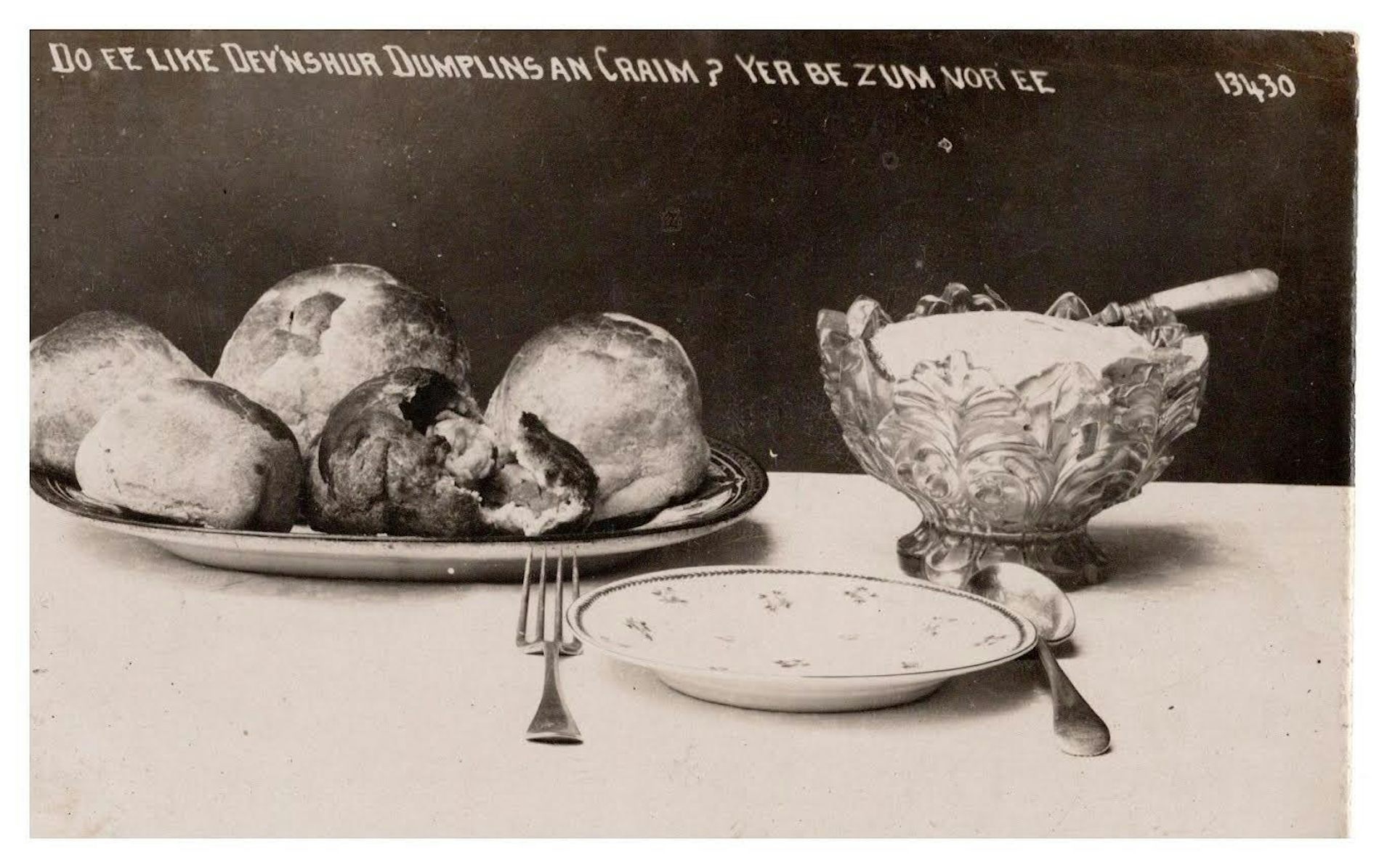 A black and white postcard showing Devonshire dumplings and cream.