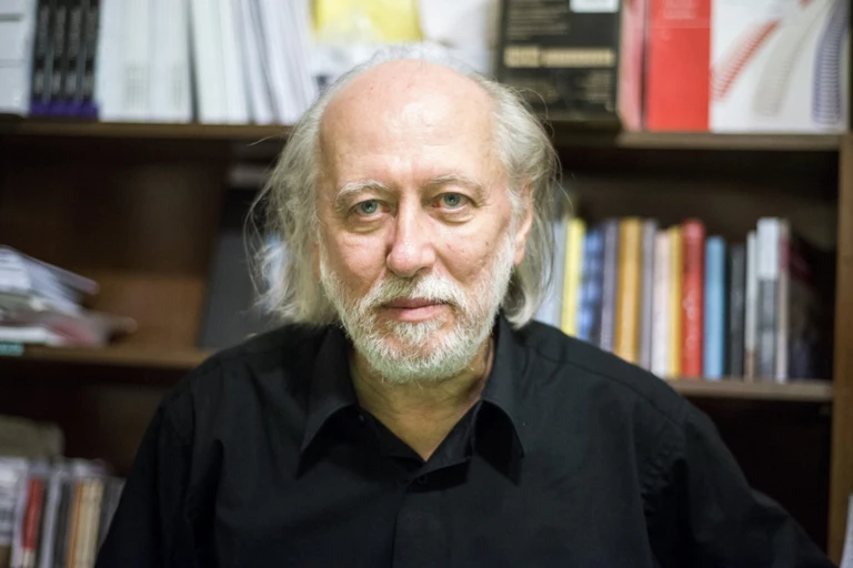 Laszlo Krasznahorkai in front of a bookcase
