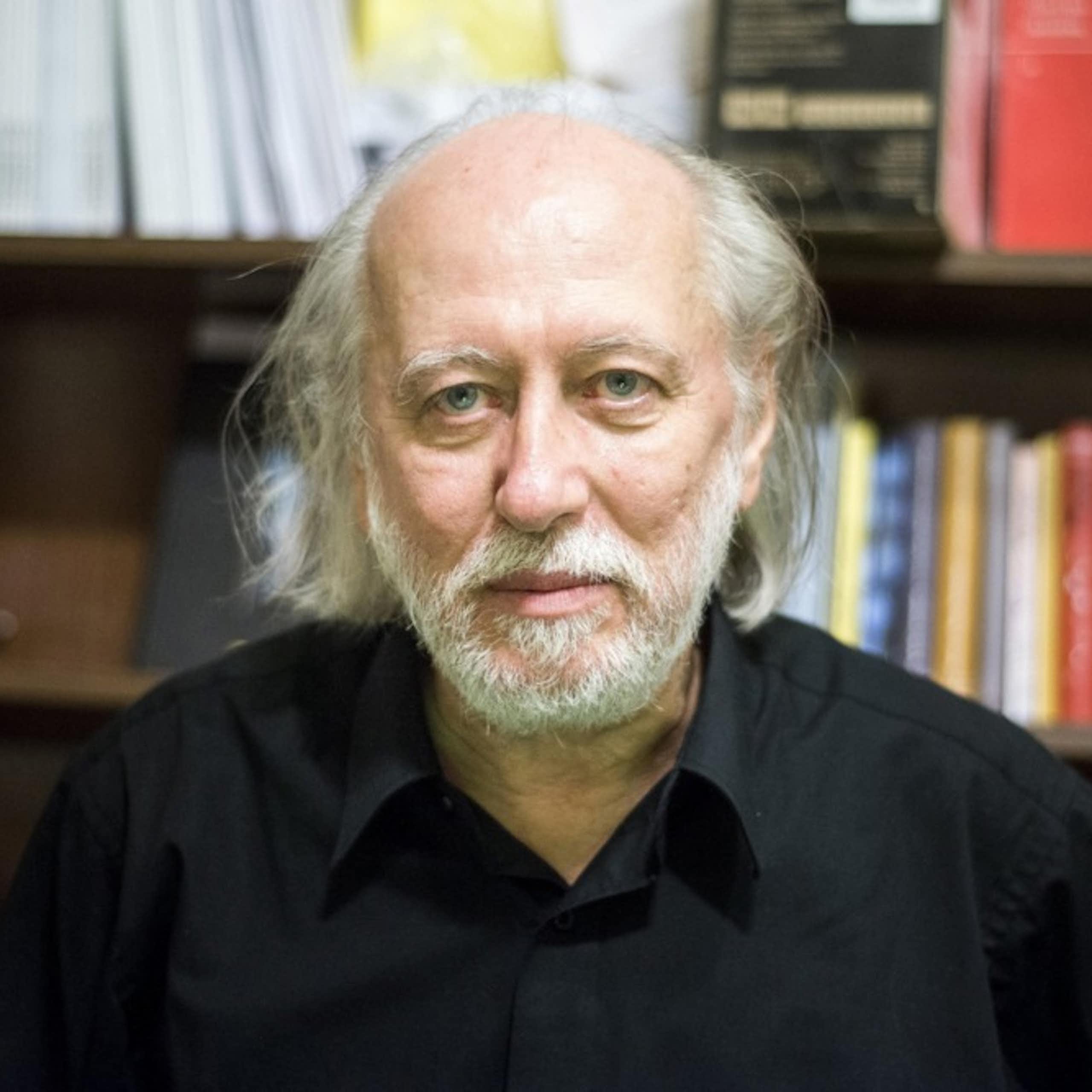 Laszlo Krasznahorkai in front of a bookcase