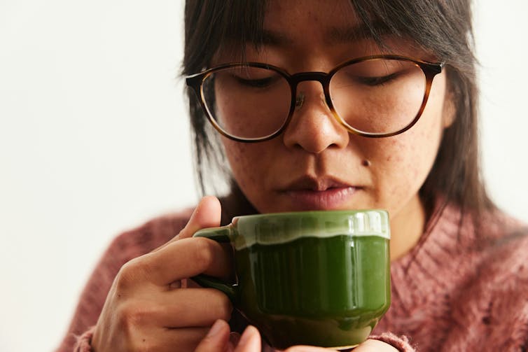 A person sipping from a mug