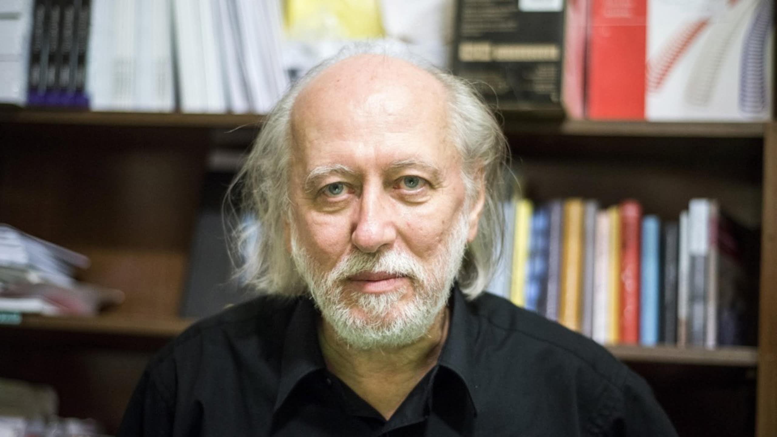 Laszlo Krasznahorkai in front of a bookcase